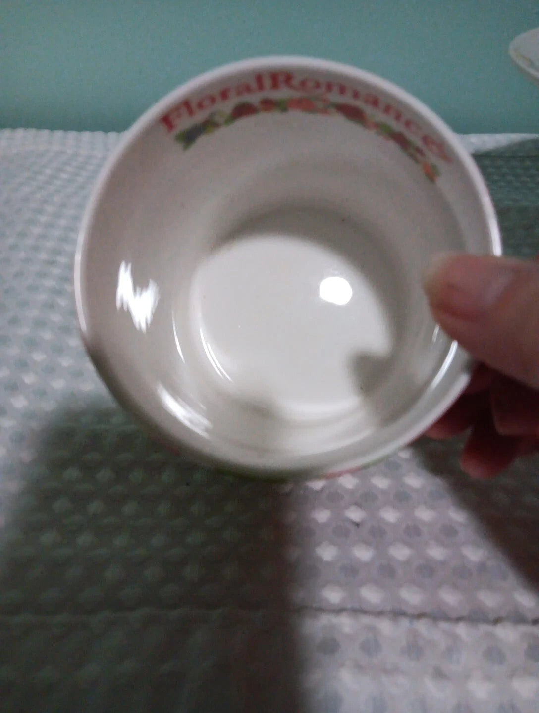 White ceramic bowl with floral patterns on a textured surface