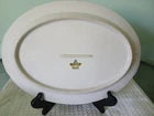 Round white plate with a gold rim on a black stand