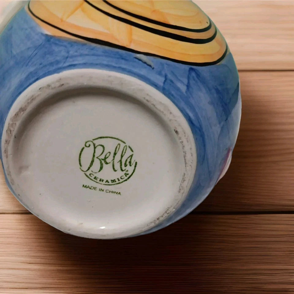 Ceramic bowl with 'Bella Ceramica' branding on a wooden surface