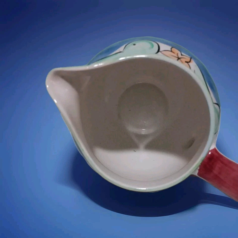 Ceramic pitcher with floral design on a blue background