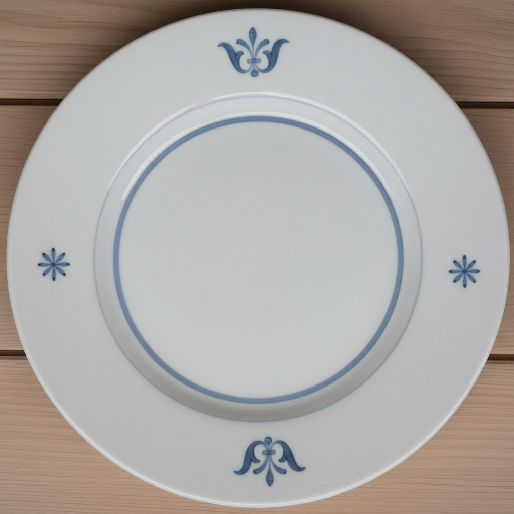 White ceramic plate with blue decorative elements on a wooden surface