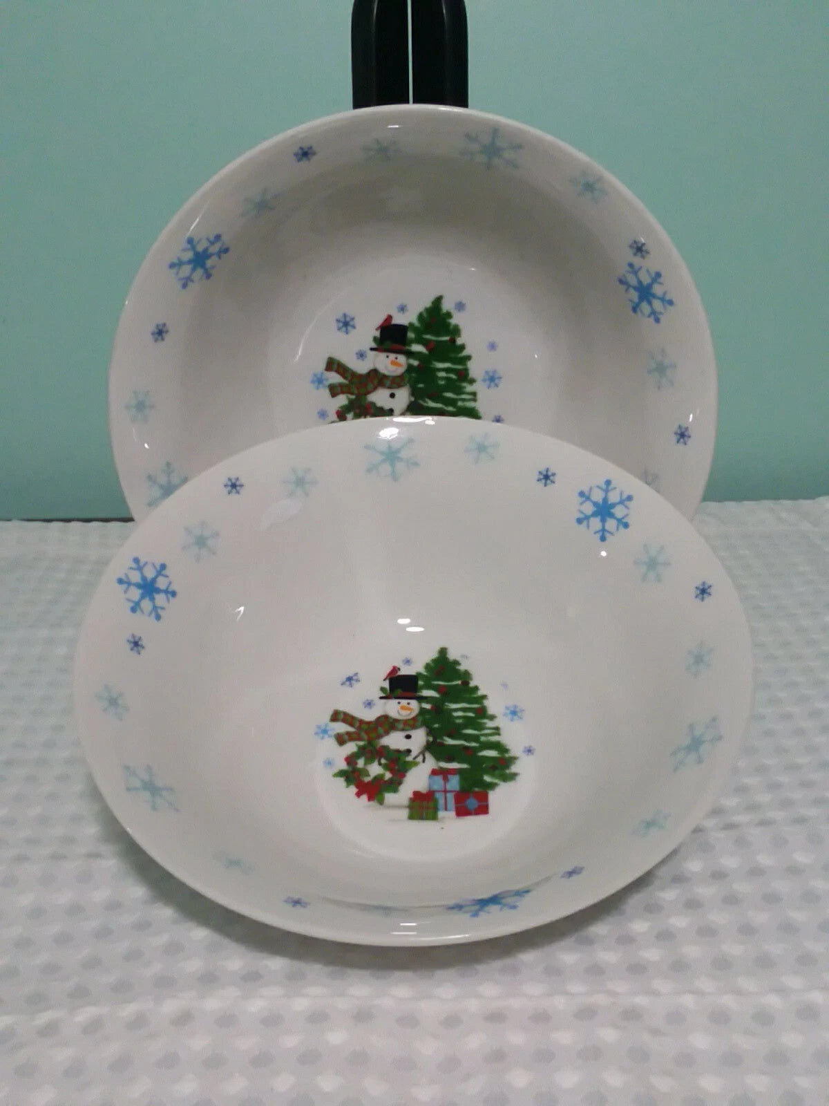 Two ceramic bowls with Christmas-themed designs on a textured surface.