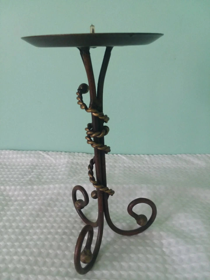 Decorative metal stand with a round plate on a light green background