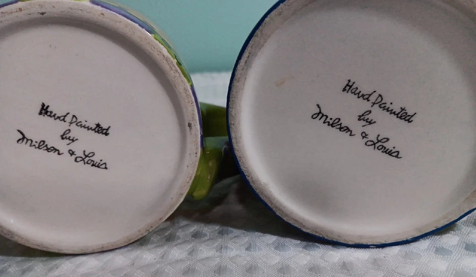 Two ceramic items with 'Hand Painted by Wilson & Sonia' inscription on a textured surface.