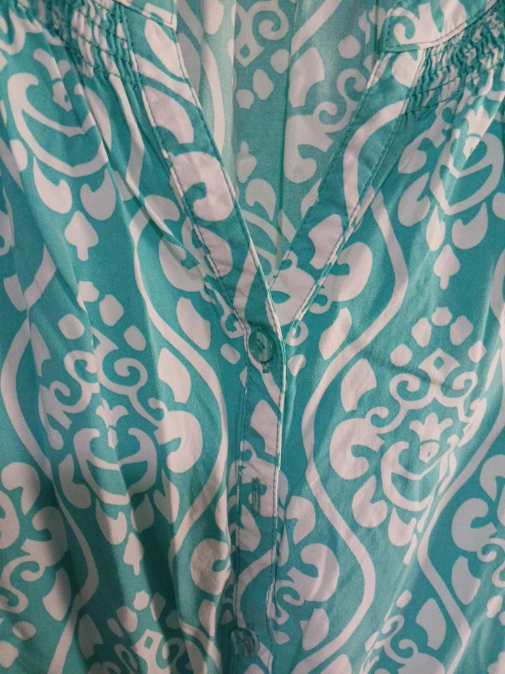 Teal and white patterned garment with a button detail