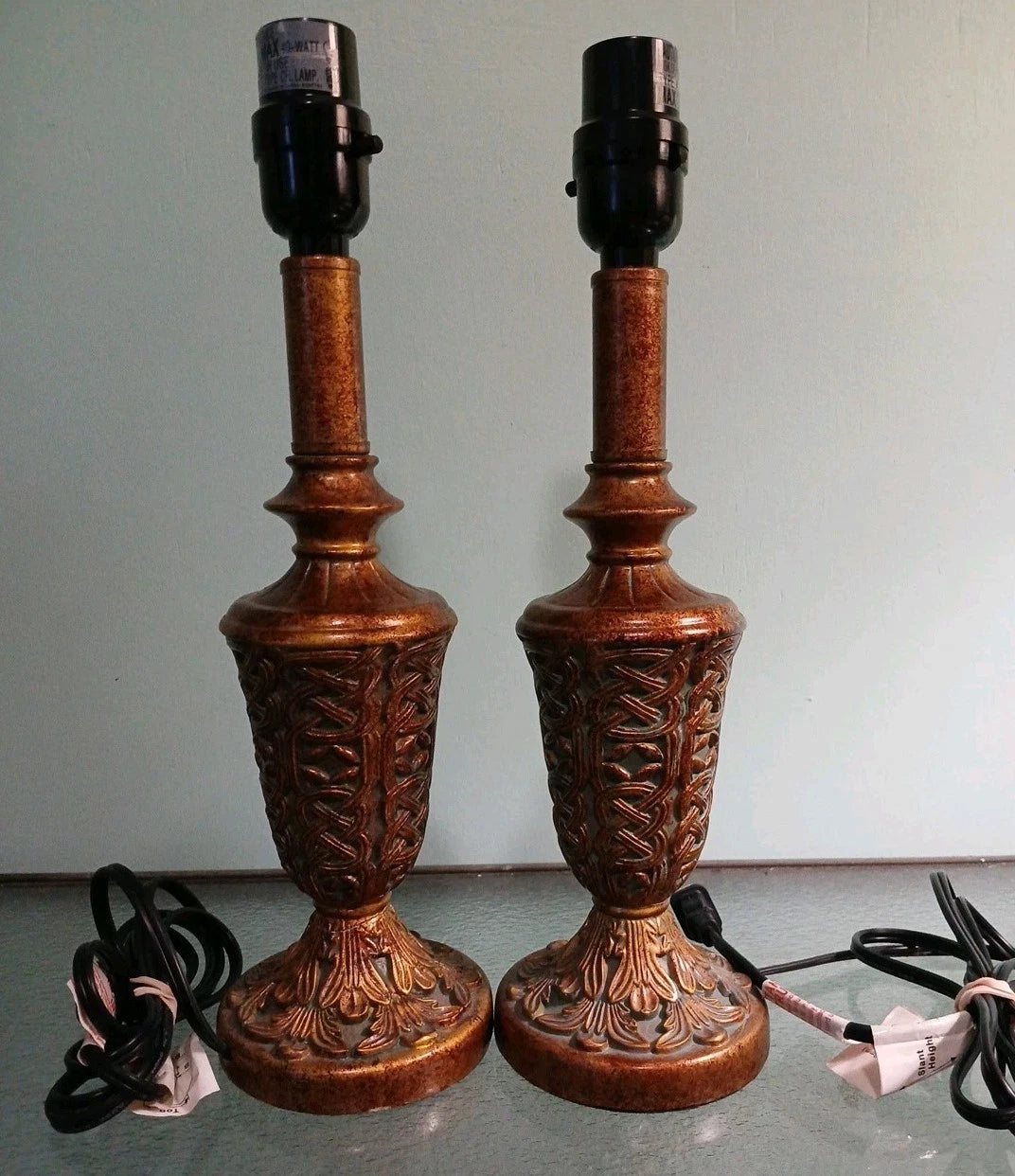 Pair of ornate wooden table lamps with intricate carvings on a plain background