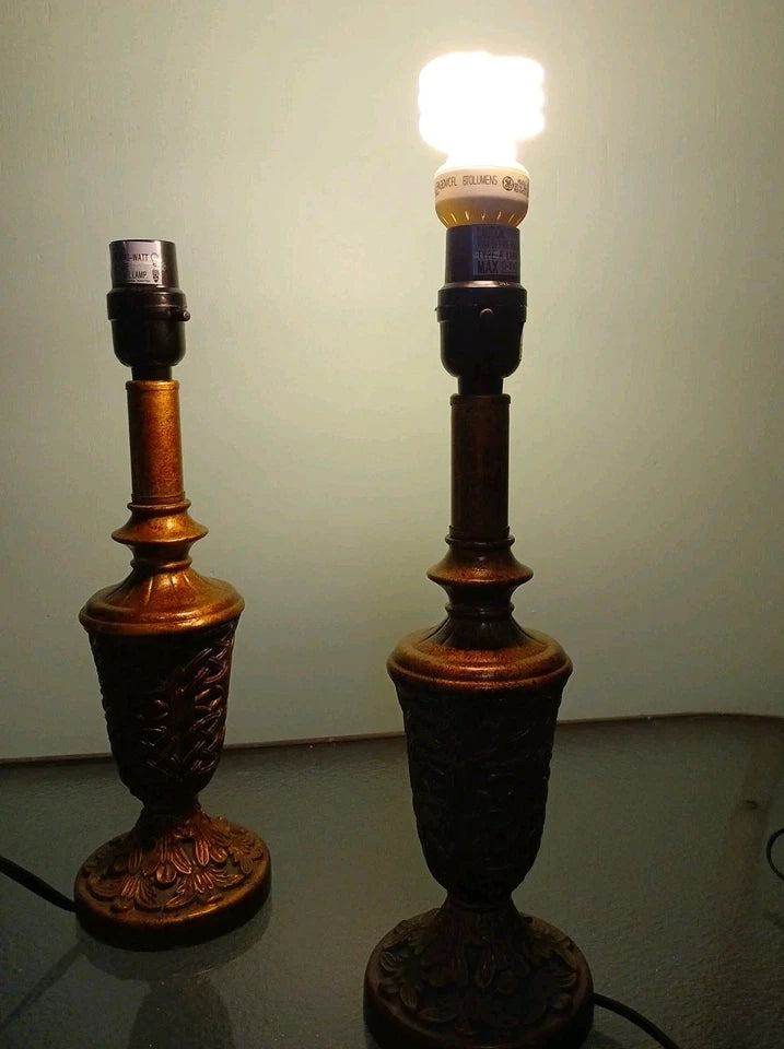 Two ornate table lamps with one turned on against a plain background