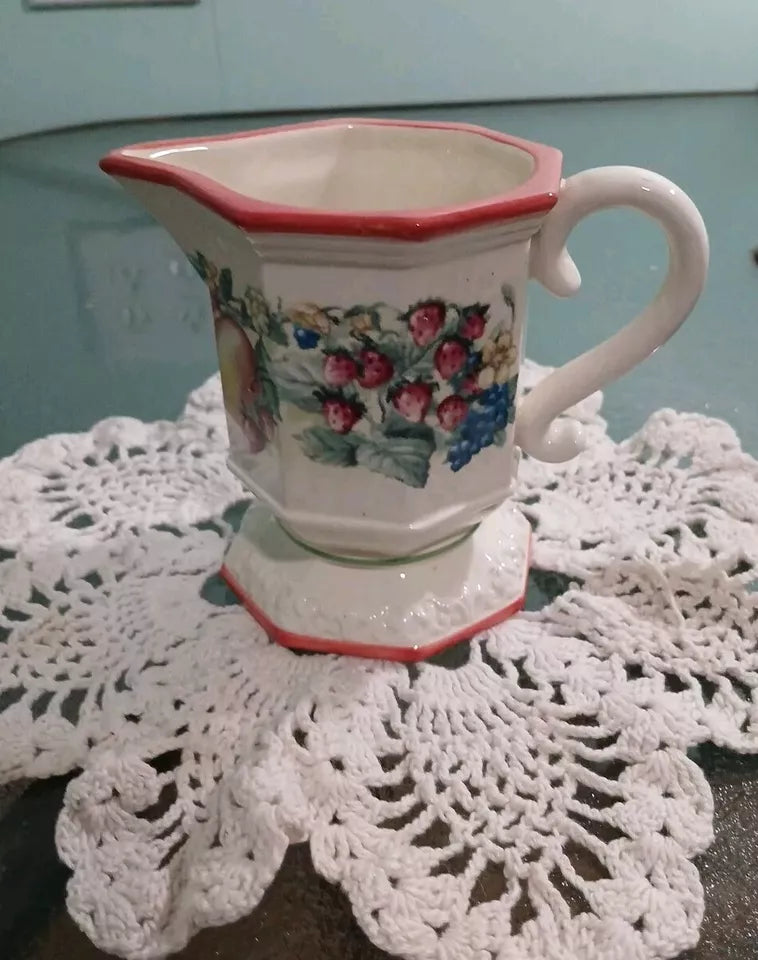 Decorative ceramic pitcher with floral design on a doily