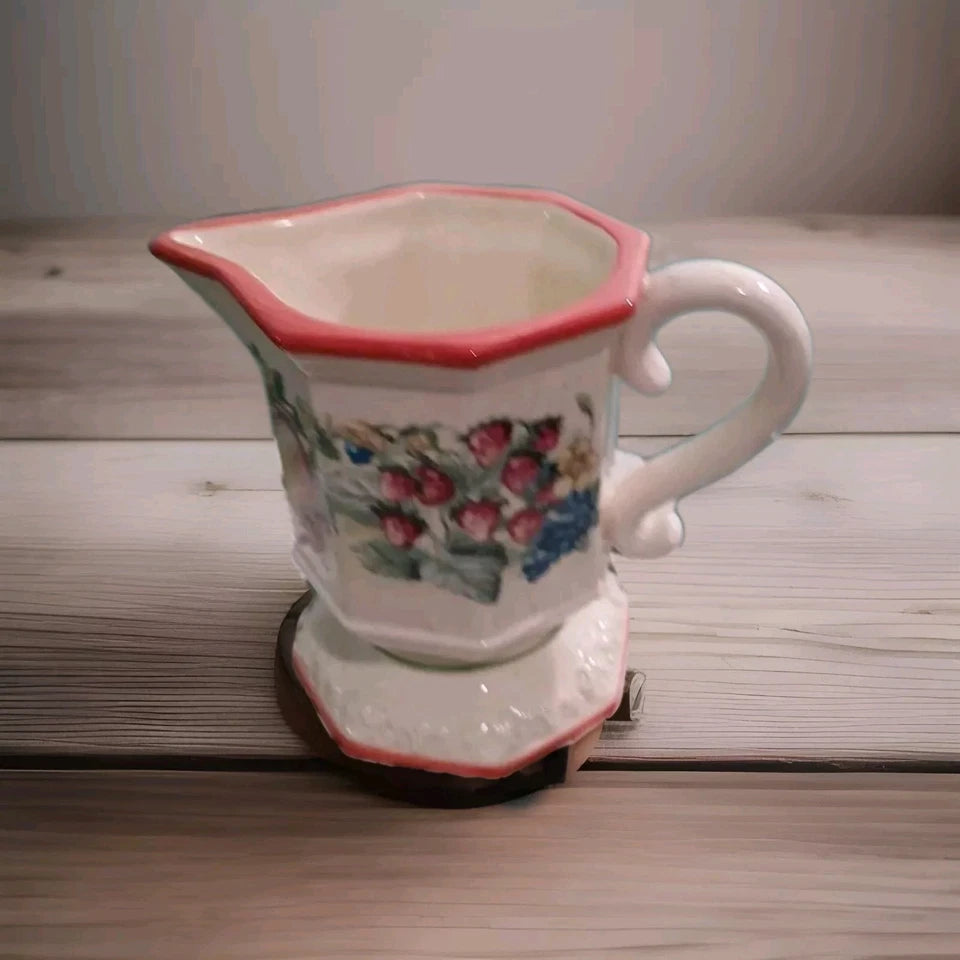 Ceramic pitcher with floral design on a wooden surface
