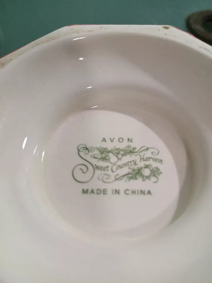 White ceramic bowl with Avon Sweet Country Harvest branding on a green background
