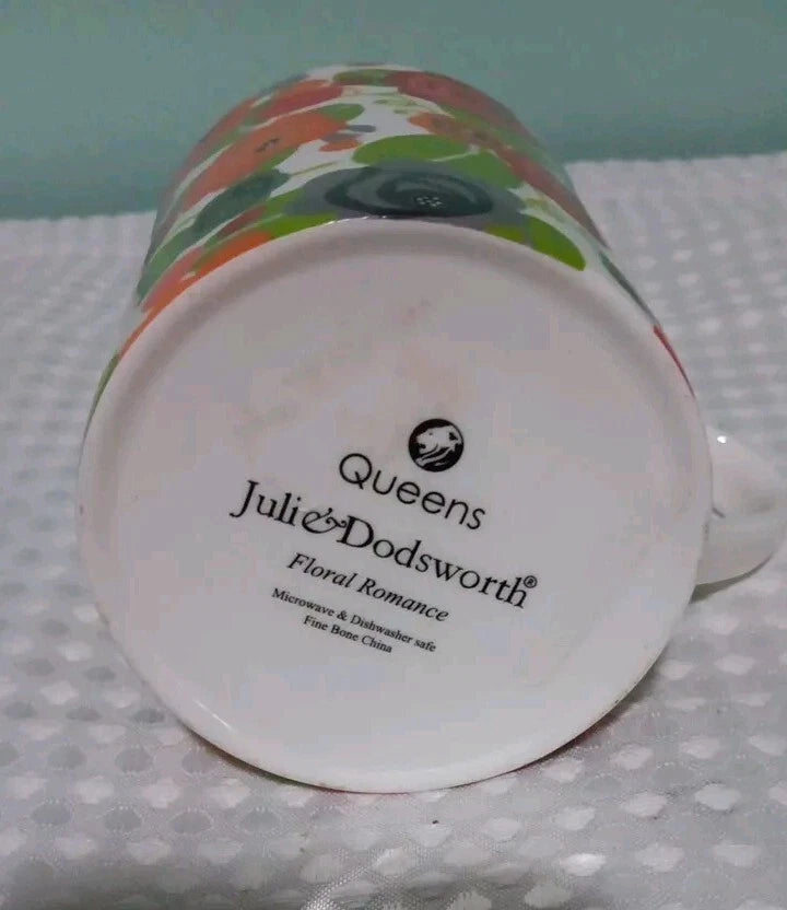 Mug with floral design and 'Queens Julie & Dodsworth' branding on a polka dot surface.