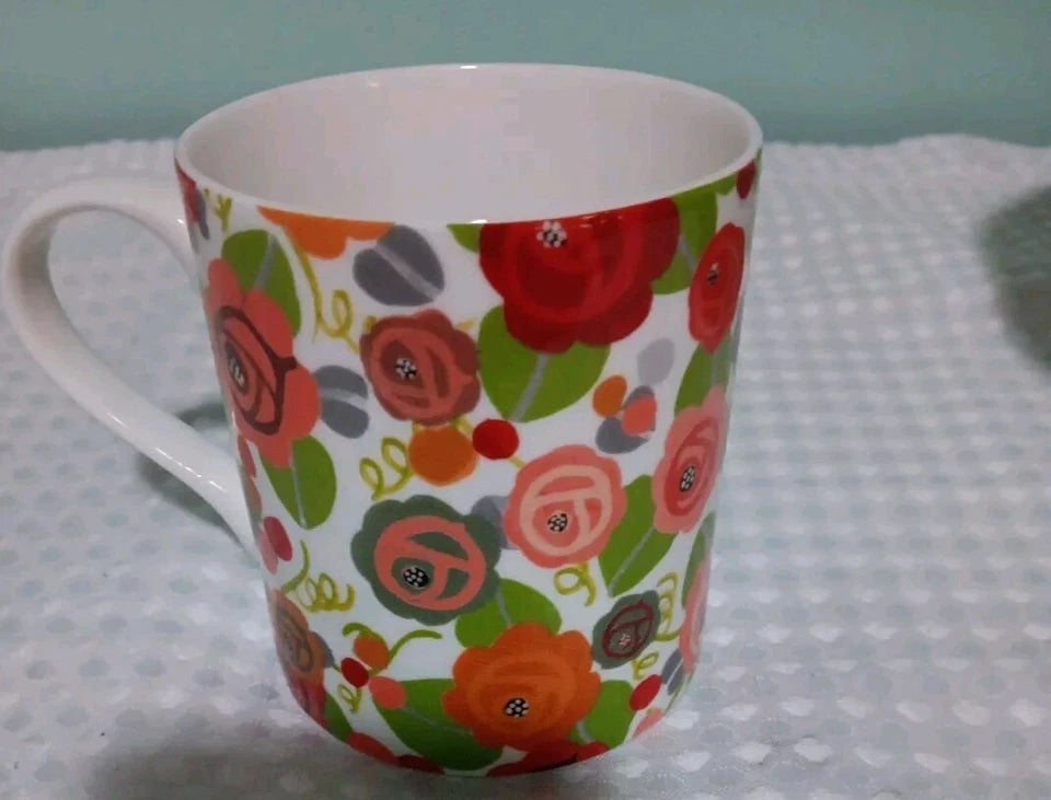 Colorful floral-patterned mug on a polka dot fabric background