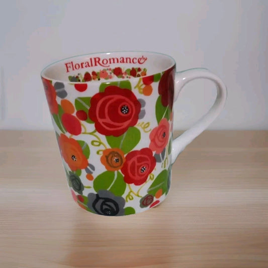 Floral mug with 'Floral Romance' branding on a wooden surface