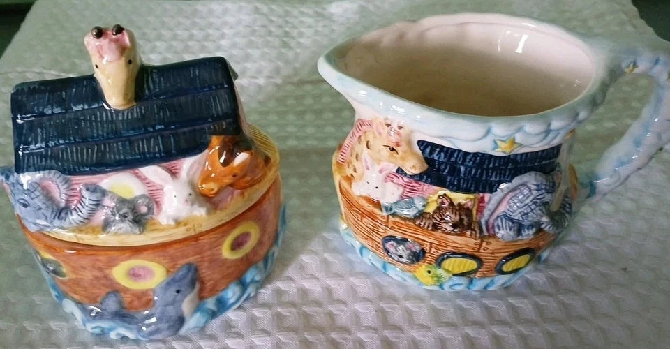 Decorative ceramic items including a Noah's Ark and a pitcher with animal designs on a textured surface.