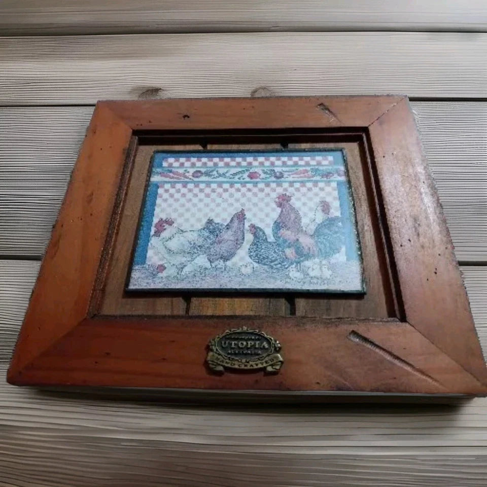 Wooden frame with a decorative tile featuring chickens on a wooden surface