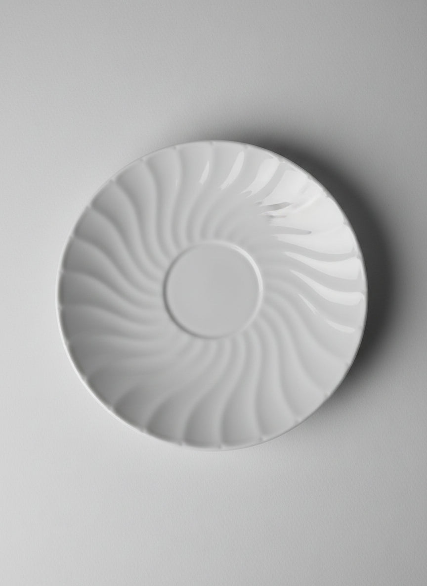 Round white porcline plate on a textured surface green bacground