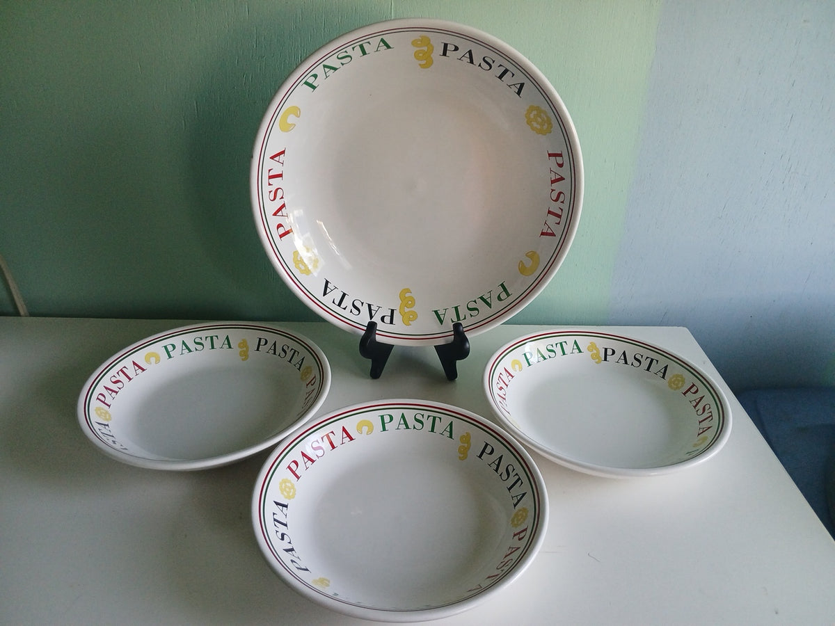 Set of four white bowls with 'Pasta' text on a light green surface