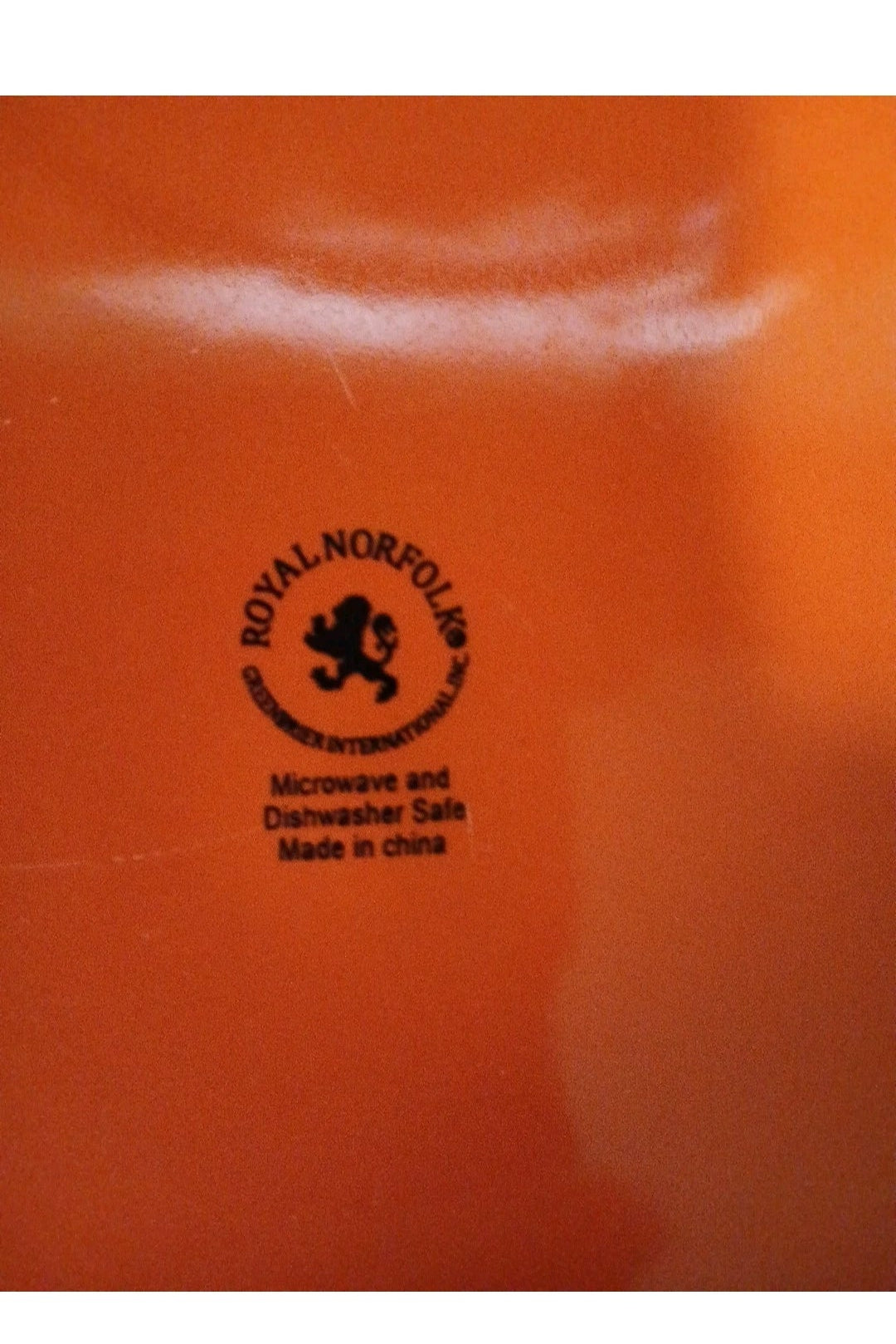 Orange plate with a black logo and text, likely a product packaging or label.