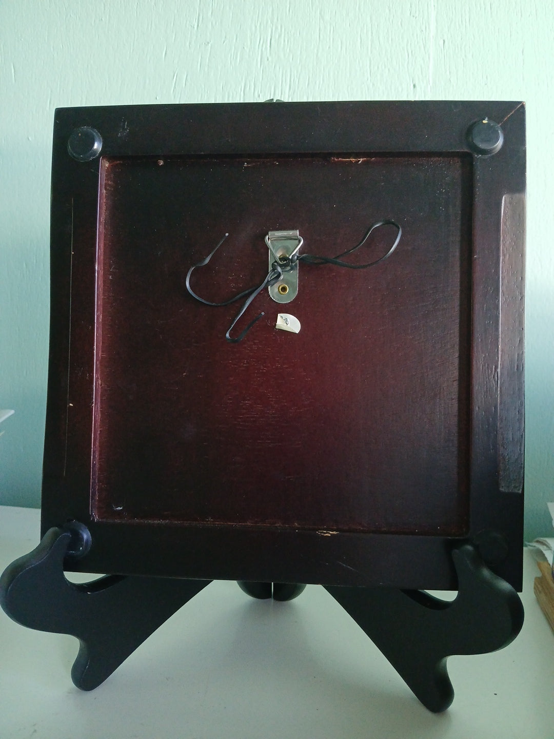 Wooden picture frame with a dark brown finish on a light green background