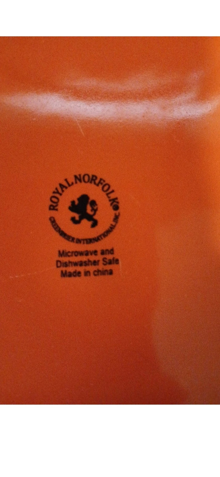  Back of an Orange plate with a black logo and text on an orange background