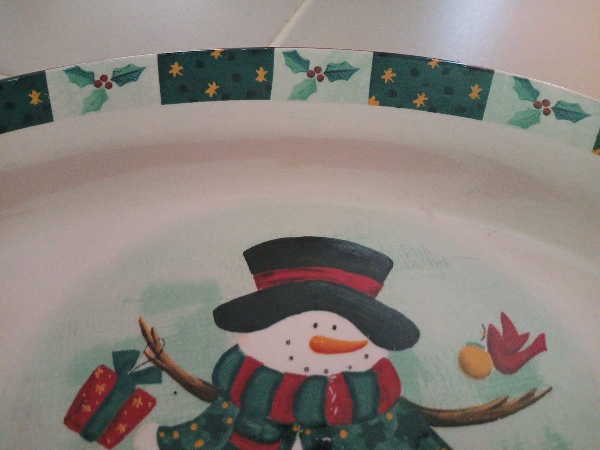 Decorative plate with a snowman design and Christmas-themed border.