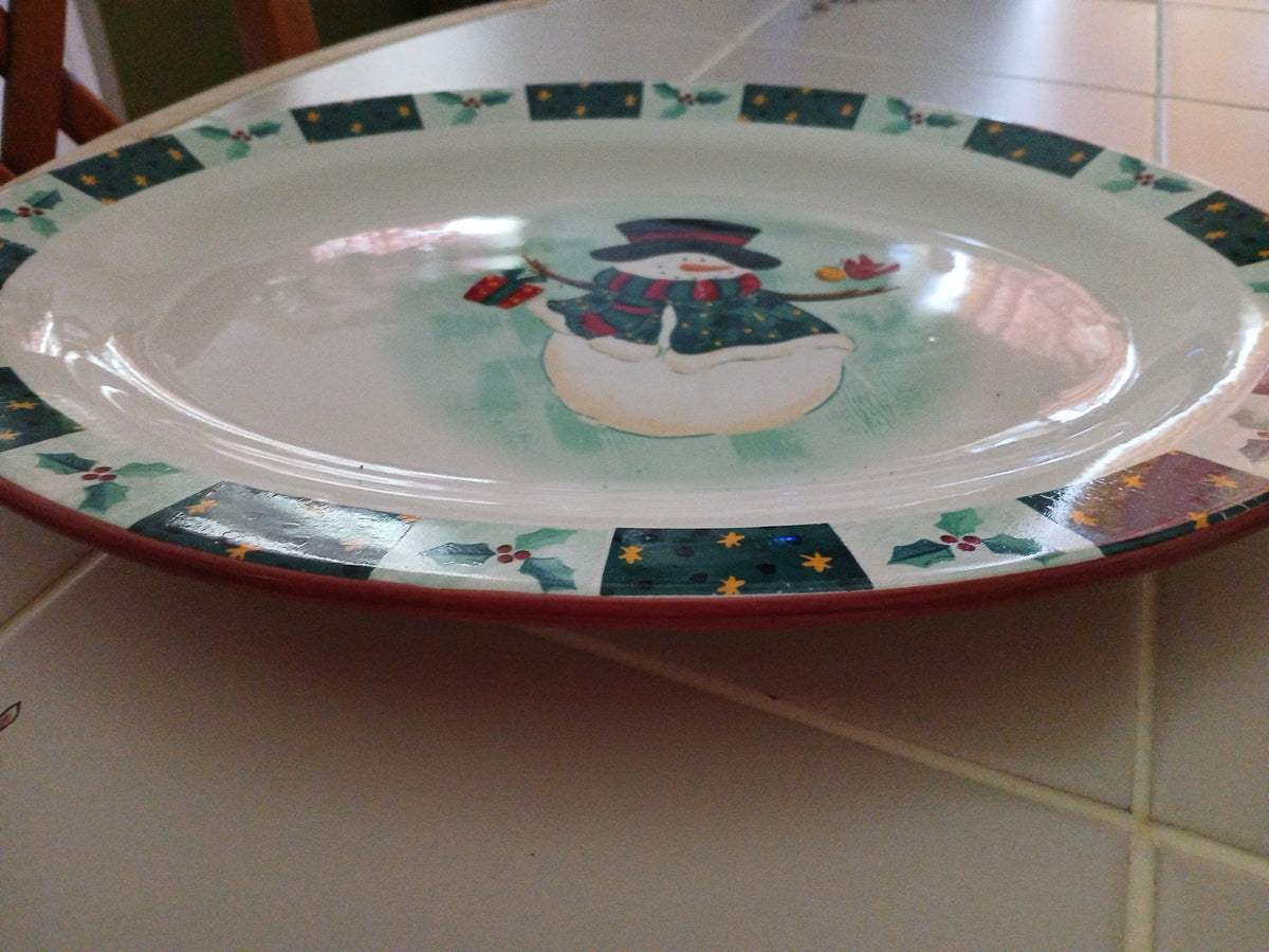Decorative plate with a snowman design on a tiled surface
