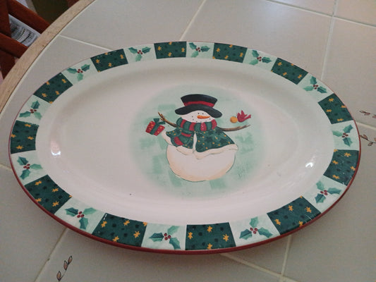 Decorative plate with a snowman design on a tiled surface