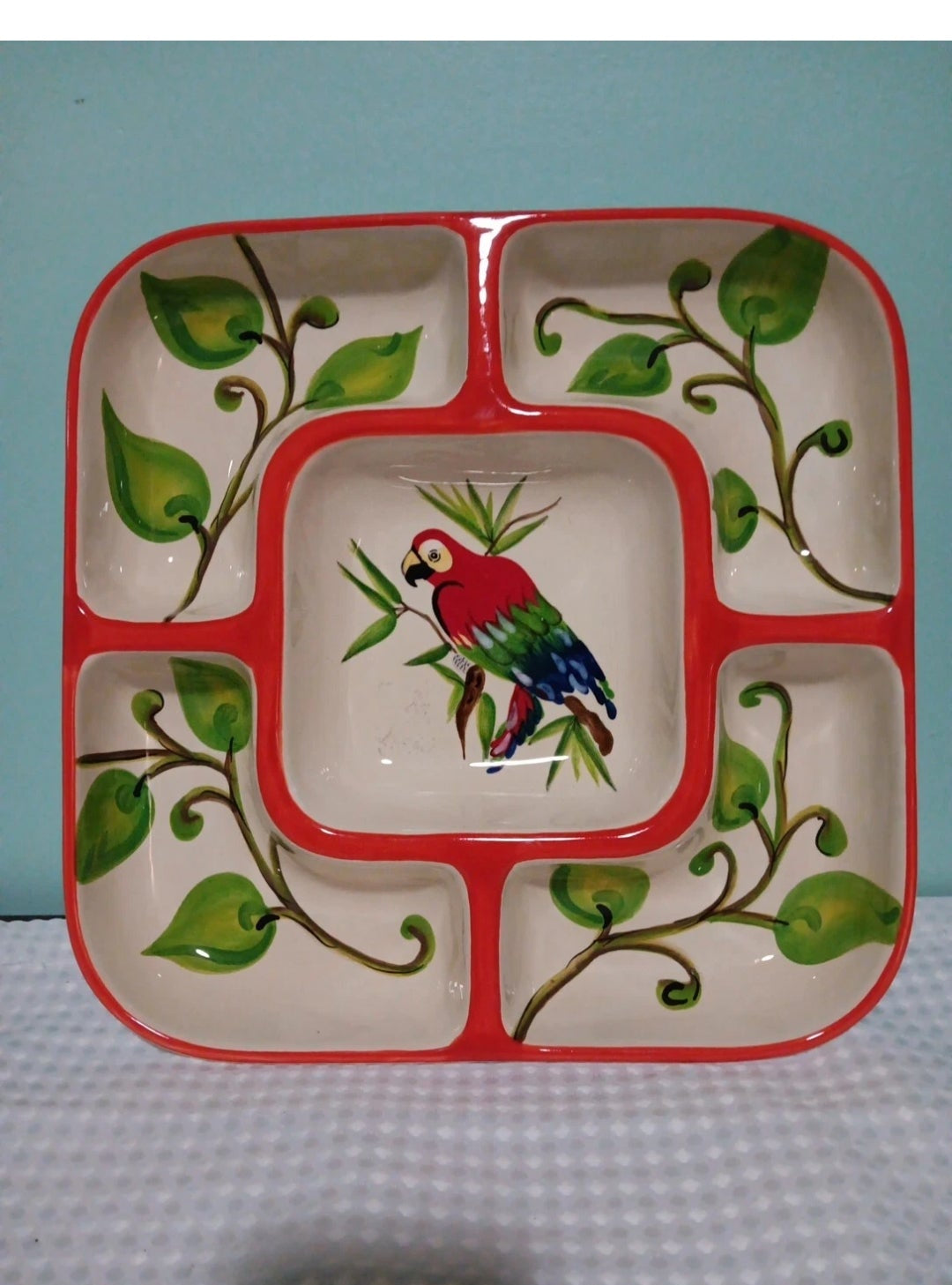 Decorative ceramic plate with a bird design on a checkered tablecloth