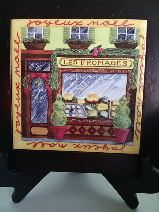 Decorative trivet with colorful design and text on a dark surface