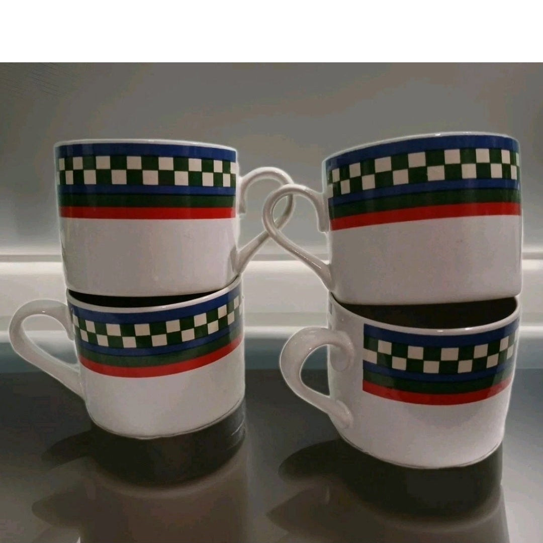 four ceramic mugs with checkered patterns on a reflective surface.