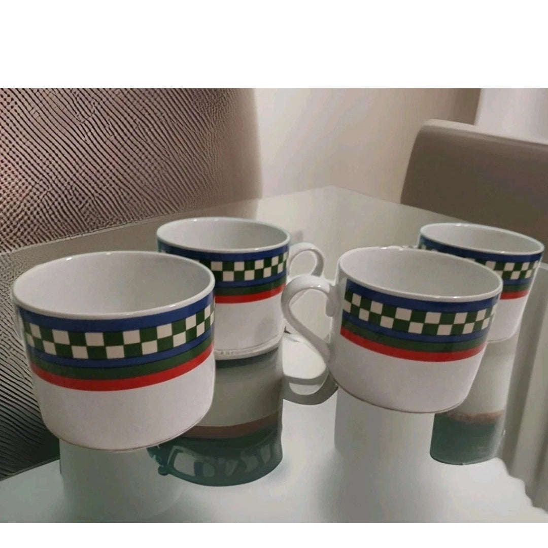 Four mugs with checkered patterns on a reflective surface