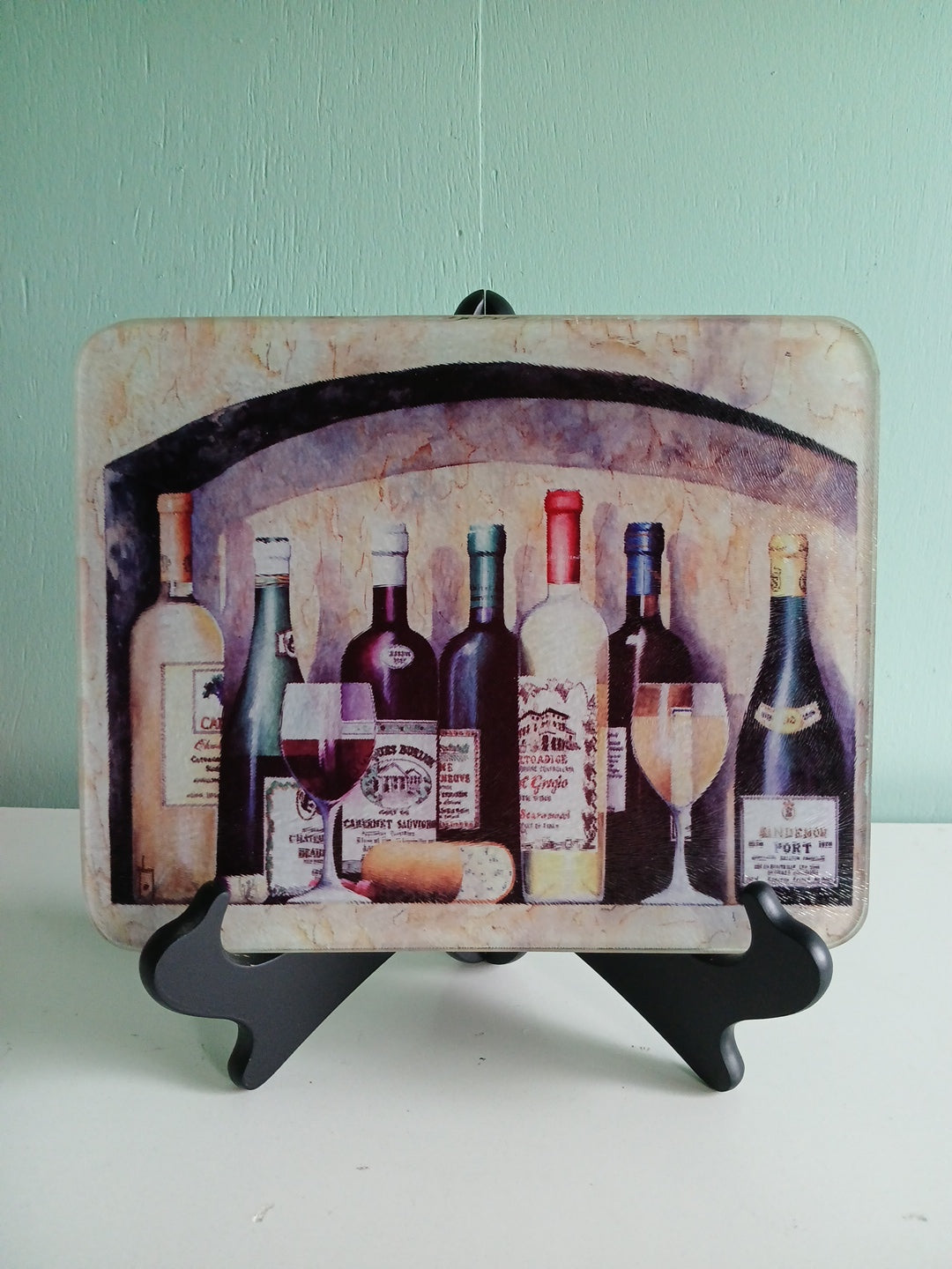 Wine bottle design on a decorative plate with a black stand against a light green background
