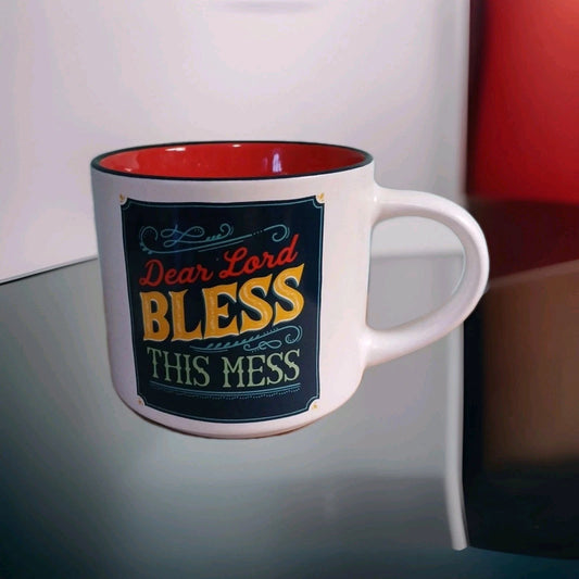Mug with 'Dear Lord BLESS this mess' text on a reflective surface.