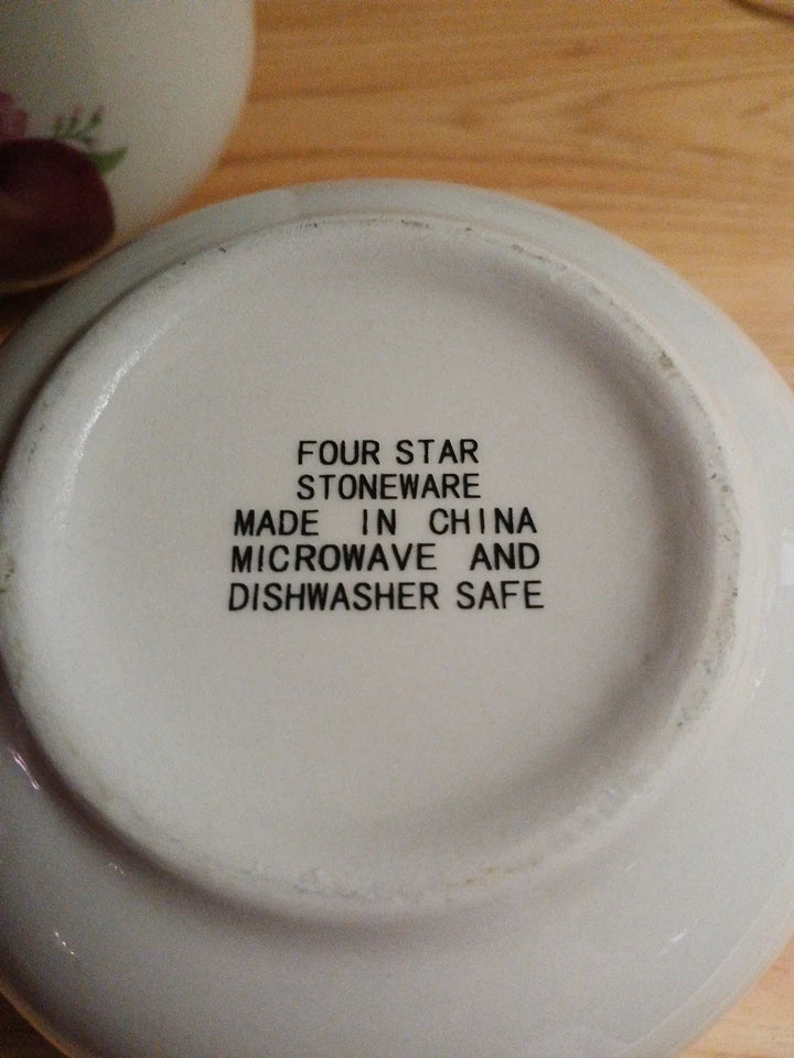 Stoneware dish with 'Four Star Stoneware' branding and safety information on a wooden surface.