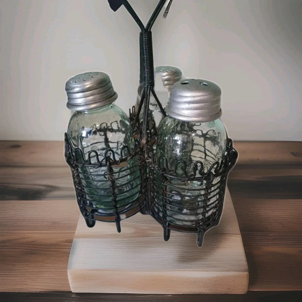 Decorative salt and pepper shakers in a metal holder on a wooden base.