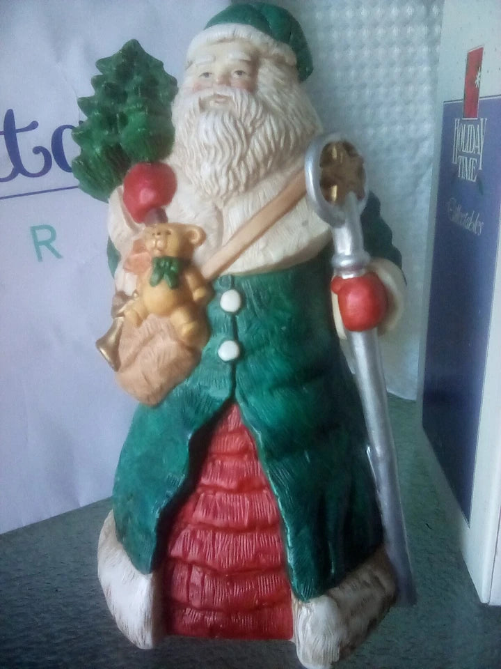 Decorative figurine of a traditional Santa Claus holding a key and a gift bag.