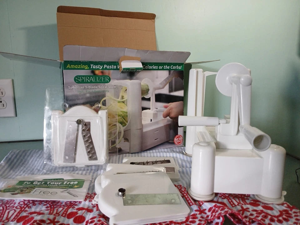 White pasta spiralizer on a table with packaging in the background