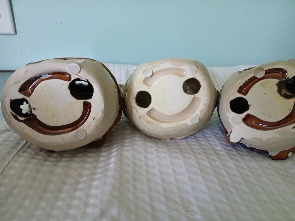 Three ceramic bowls with smiley face designs on a textured surface.
