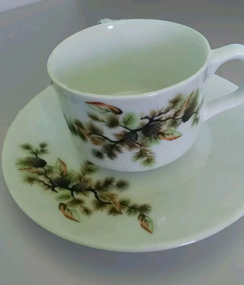 Teacup and saucer with tree design on a white background