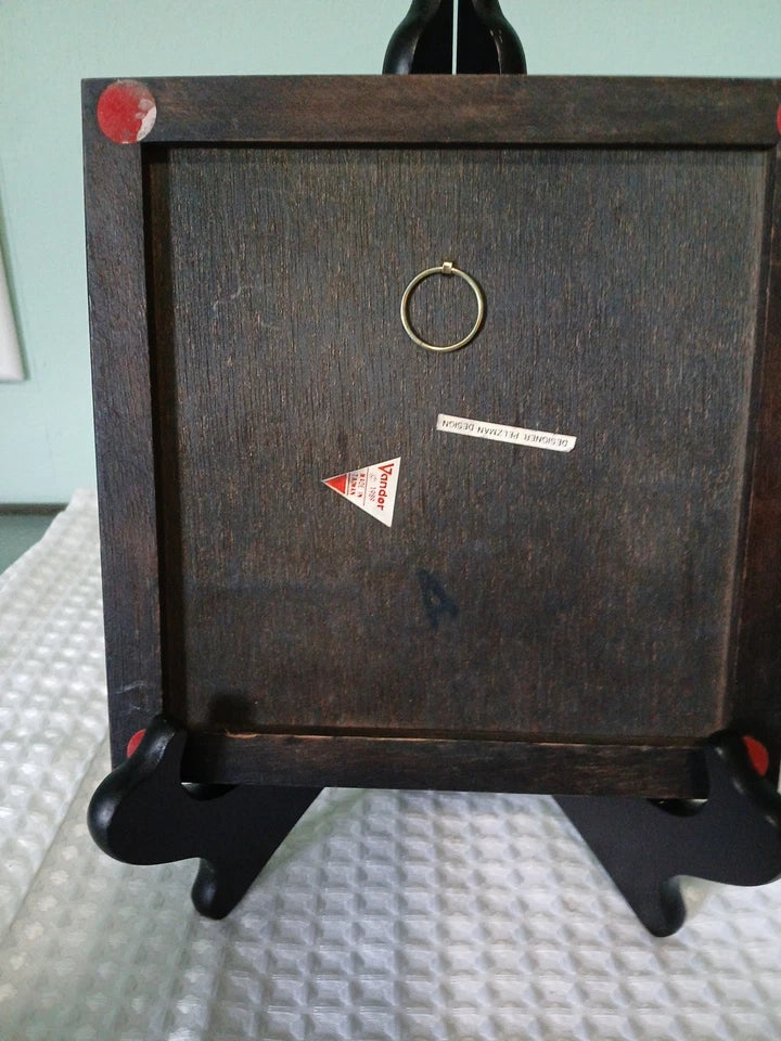 Back of picture with a circular object and triangle warning symbol on a stand.