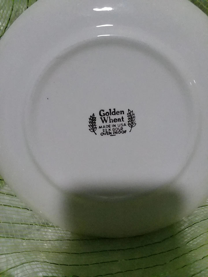 White plate with 'Golden Wheat' branding on a green woven surface